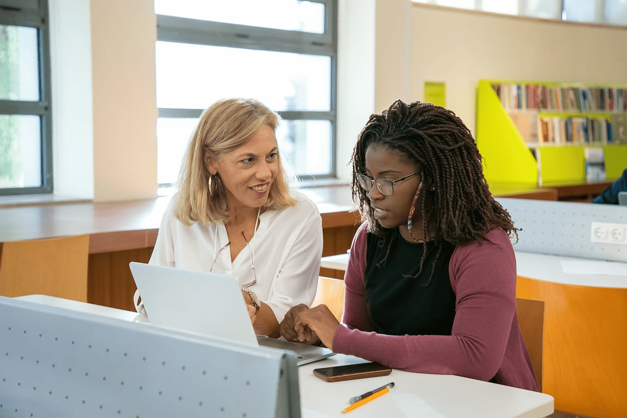 University specialist and student working together in library.